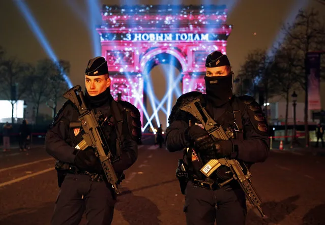 Policemen secure the Champs Elysees Avenue as Revellers gather during New Year celebrations in Paris,France, late December 31, 2016. (Photo by Jacky Naegelen/Reuters)