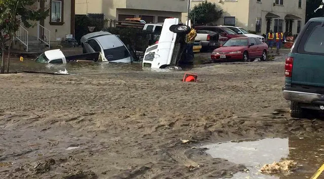 This photo provided by nbc4 shows vehicles that have fallen into a sinkhole on a street flooded by a predawn rupture of a water main in a Los Angeles neighborhood, forcing residents to flee their homes and leaving several vehicles submerged Friday, December 21, 2018. Fire and utility crews were sent to the area, where water flowed for hours. About 40 people were evacuated, the Los Angeles Department of Water and Power said. At one point, a woman fell into an unseen hole after stepping into the water during the evacuation. (Photo by Fabian Rodriguez/nbc4 via AP)