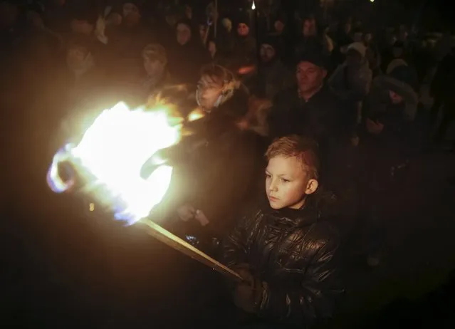 A boy holds a torch as activists and supporters of the Svoboda (Freedom), Ukrainian nationalist party, march to honour students killed during a military conflict in 1918 in Kiev, Ukraine January 29, 2016. Several hundred students were killed during a battle against troops of th Bolshevik movement, which included Petrograd and Moscow Red Guards, on January 29, 1918, according to local media. (Photo by Valentyn Ogirenko/Reuters)