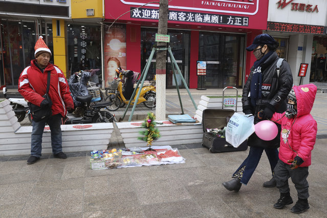 In this Saturday, December 22, 2018, photo, a man sells Christmas decorations on a street of Zhangjiakou in northern China's Hebei province. At least four Chinese cities and one county have restricted Christmas celebrations this year. Churches in another city have been warned to keep minors away from Christmas, and at least ten schools nationwide have curtailed Christmas on campus, The Associated Press has found. (Photo by Ng Han Guan/AP Photo)
