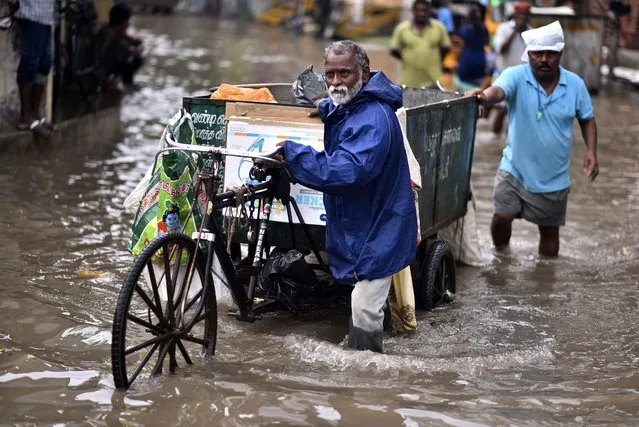 Municipal workers wade with a garbage cart through a waterlogged road following heavy rains, in Chennai, India, 25 November 2023. The Indian Meteorological Department (IMD) predicted more rainfall and issued a thunderstorm warning for several districts of Tamil Nadu and Puducherry on 25 November. Authorities declared a holiday for schools in Chennai as overnight rain caused waterlogging in several parts of the city. (Photo by Idrees Mohammed/EPA)