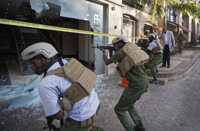 Security forces point their weapons through a shattered door behind which an unexploded grenade lies, at a hotel complex in Nairobi, Kenya, Tuesday, January 15, 2019. Terrorists attacked an upscale hotel complex in Kenya's capital Tuesday, sending people fleeing in panic as explosions and heavy gunfire reverberated through the neighborhood. (Photo by Ben Curtis/AP Photo)