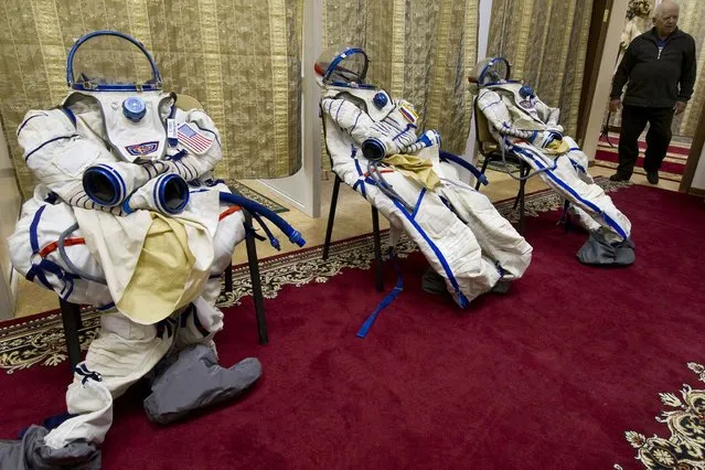The spacesuits of European Space Agency Italian astronaut Samantha Cristoforetti (R), US astronaut Terry Virts (L) and Russian cosmonaut Anton Shkaplerov (C) are prepared for their preflight training session at the Gagarin Cosmonauts' Training Centre in Star City centre outside Moscow, on December 10, 2013. All three are scheduled to blast off to the International Space Station (ISS) from the Russian leased Kazakhstan's Baikonur cosmodrome in November 2014. (Photo by AFP Photo)