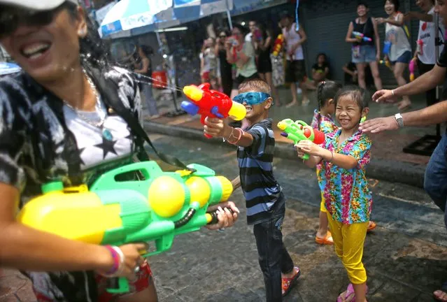 Thai children join the street fun and spray a woman with water from giant water pistols at the popular tourist strip Khao San road on the first day of the water festival Songkran celebrations, the Thai traditional New Year, in Bangkok, Thailand, 12 April 2015. (Photo by Fazry Ismail/EPA)