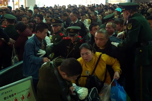 Paramilitary police officers keep passengers in order as they enter a railway station in Fuzhou, Fujian province, January 30, 2019. Hundreds of millions of Chinese are on the move ahead of the Lunar New Year holiday. (Photo by Reuters/China Stringer Network)