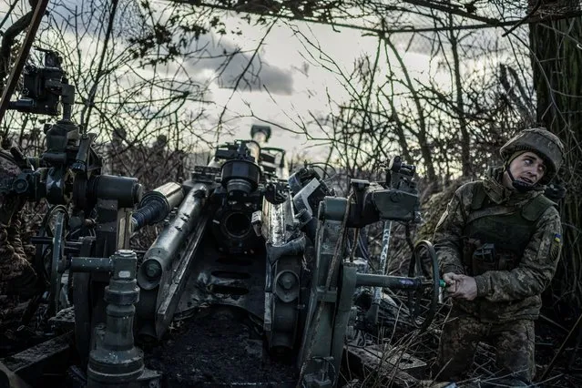 A Ukrainian serviceman of the 55th Separate Artillery Brigade prepares a M777 howitzer to fire toward Russian troops, at a position near the front line town of Marinka, amid Russia's attack on Ukraine, in Donetsk region, Ukraine on December 26, 2023. (Photo by Viacheslav Ratynskyi/Reuters)