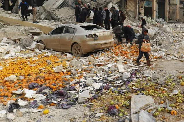 A boy carries oranges amidst rubble of damaged buildings after an airstrike on a market in rebel held Maarrat Misrin city in Idlib province, Syria January 14, 2017. (Photo by Ammar Abdullah/Reuters)