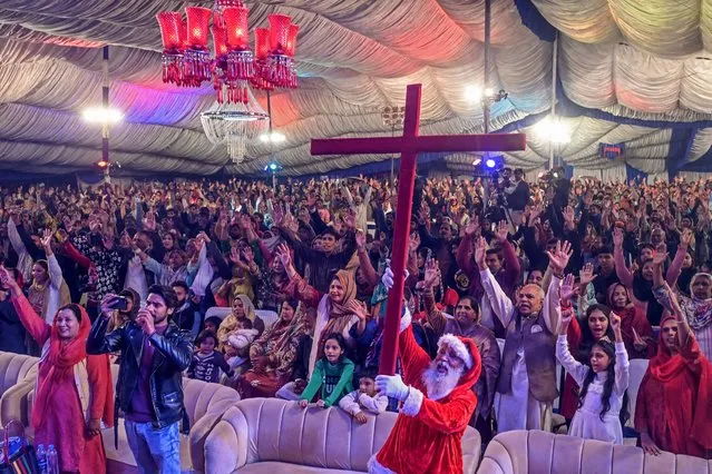 Christian devotees take part in a special mass ahead of Christmas, at a church in Lahore on December 20, 2023. (Photo by Arif Ali/AFP Photo)