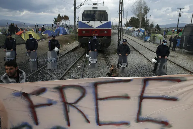 Migrants hold a banner as they block the railway track at the Greek-Macedonian border, near the village of Idomeni, Greece March 3, 2016. (Photo by Marko Djurica/Reuters)