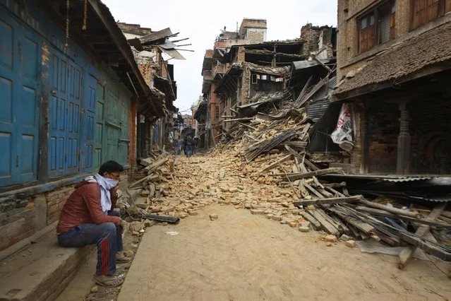 A Nepalese man mourns as he sits near the debris after an earthquake in Bhaktapur near Kathmandu, Nepal, Sunday, April 26, 2015. (Photo by Niranjan Shrestha/AP Photo)