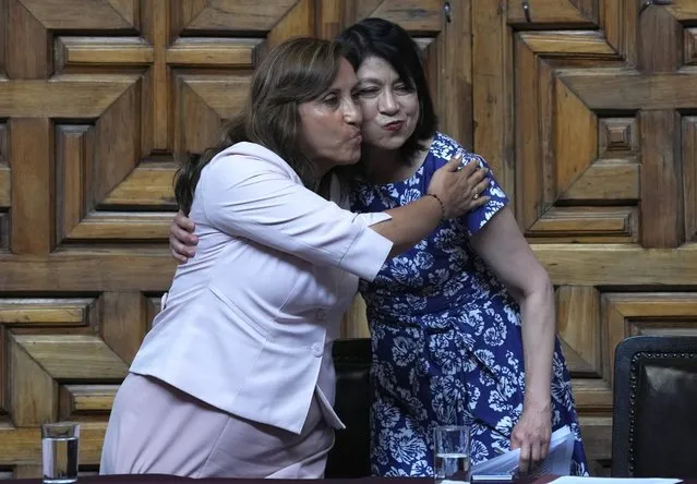 Peru's President Dina Boluarte, left, and Foreign Minister Ana Cecilia Gervasi embrace during a ceremony at the Foreign Ministry in Lima, Peru, Tuesday, December 20, 2022. Peru's Congress is slated to consider a proposal on Tuesday to push up elections that have been a major demand of protesters blocking highways and clashing with security forces in deadly demonstrations across the country over the ouster of President Pedro Castillo. (Photo by Martin Mejia/AP Photo)