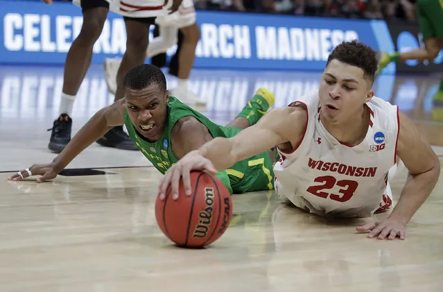 Wisconsin guard Kobe King (23) dives for the ball in front of Oregon forward Louis King during the second half of a first-round game in the NCAA men's college basketball tournament Friday, March 22, 2019, in San Jose, Calif. (Photo by Ben Margot/AP Photo)