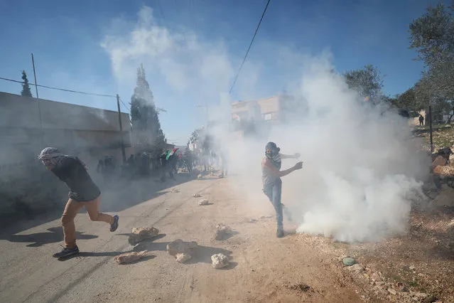 A Palestinian protester throws back a tear gas canister fired by Israeli troops during clashes following a protest against the near-by Jewish settlement of Qadomem, in the West Bank village of Kofr Qadom near Nablus February 3, 2017. (Photo by Mohamad Torokman/Reuters)