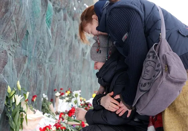 People react as they lay flowers at the Wall of Grief monument to the victims of political repressions to honour the memory of Russian opposition leader Alexei Navalny in Moscow, Russia on February 17, 2024. (Photo by Reuters/Stringer)
