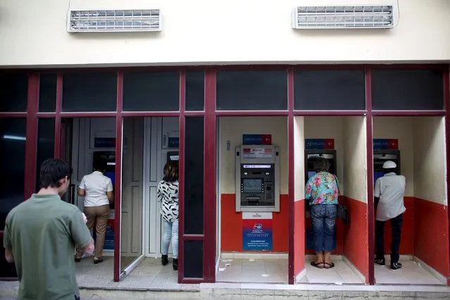 People  use an automated teller machine (ATM) in downtown Havana, March 15, 2016. (Photo by Alexandre Meneghini/Reuters)