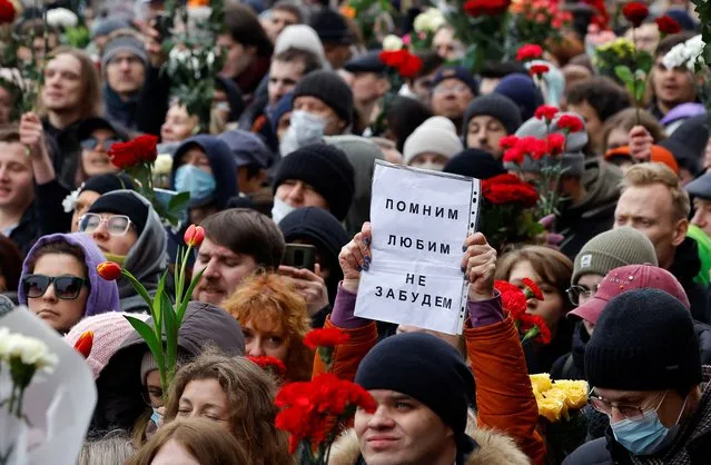 People walk towards the Borisovskoye cemetery during the funeral of Russian opposition politician Alexei Navalny in Moscow, Russia, on March 1, 2024. A placard reads: “We remember, we love, we won't forget”. (Photo by Reuters/Stringer)