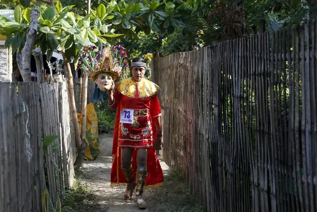 Penitent and housewife Ella Mazon carries her “Morions” mask as she walks in an alley outside her house, during Holy Week celebrations in Mogpog, Marinduque in central Philippines March 22, 2016. (Photo by Erik De Castro/Reuters)