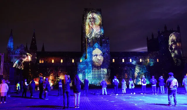 People look at In our hearts blind hope by Palma Studio and Richard Hammarton, projected onto the Durham Cathedral during during a preview of Lumiere Durham, the UK's largest light festival on Wednesday, November 17, 2021. (Photo by Owen Humphreys/PA Images via Getty Images)
