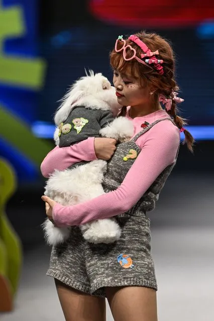 A model holds a rabbit as she walks at a pet fashion show during the Pet joy Fashion week 2024 at the Yangpu district in Shanghai on March 25, 2024. (Photo by Hector Retamal/AFP Photo)