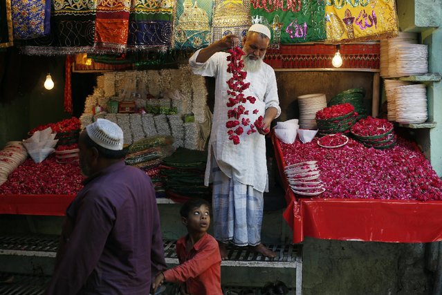 A vendor arranges garlands to display at his shop outside the Nizamuddin Dargah, a shrine of Sufi saint Hazrat Nizamuddin Auliya, in New Delhi, India, April 8, 2016. (Photo by Adnan Abidi/Reuters)
