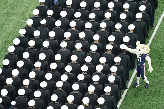 Naval academy mascot Bill the Goat, takes a Navy midshipman's hat as they march onto the field before an NCAA college football game against Army, Saturday, December 11, 2021, in East Rutherford, N.J. (Photo by Matt Rourke/AP Photo)