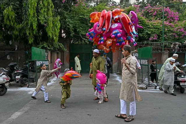Children play with balloons after offering Eid al-Fitr prayers, which marks the end of the holy fasting month of Ramadan, outside the Jama Masjid (mosque) in the old quarters of New Delhi on April 11, 2024. (Photo by Money Sharma/AFP Photo)