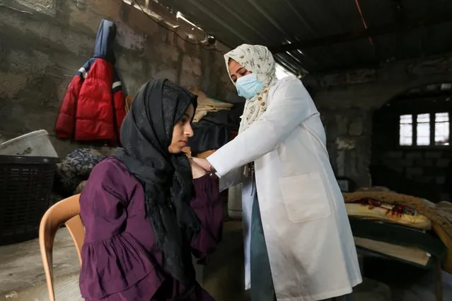 A Palestinian medical worker vaccinates a Palestinian woman against the coronavirus disease (COVID-19), in Khan Younis in southern Gaza Strip on December 12, 2021. (Photo by Ibraheem Abu Mustafa/Reuters)