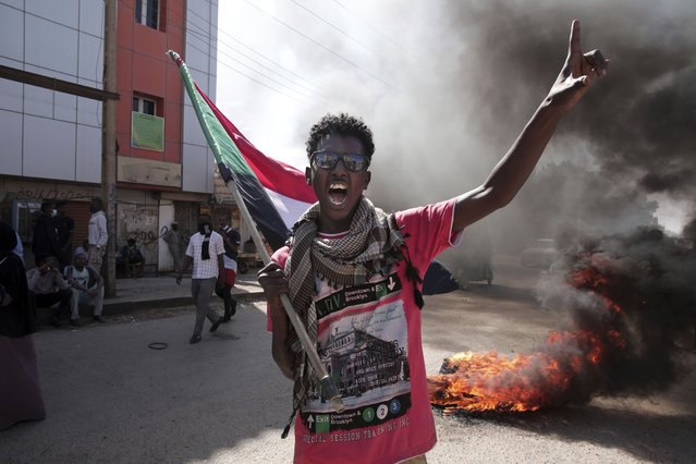 A man chants slogans during a protest to denounce the October military coup, in Khartoum, Sudan, Saturday, December 25, 2021. Sudanese security forces fired tear gas to disperse protesters as thousands rallied since earlier in the day, even as authorities tightened security across Khartoum, deploying troops and closing all bridges over the Nile River linking the capital with its twin city of Omdurman and the district of Bahri, the state-run SUNA news agency reported. (Photo by Marwan Ali/AP Photo)