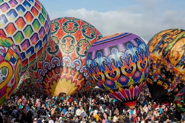 Participants prepare to fly hot air balloons during the traditional hot air balloon festival, an annual event since 1950, during the Eid al-Fitr holiday celebrating the end of the Muslim holy fasting month of Ramadan, in Wonosobo, Central Java on April 11, 2024. (Photo by Devi Rahman/AFP Photo)