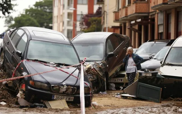 A woman speaks on the phone next to damaged cars after heavy rainfall in Tafalla, Spain, July 9, 2019. (Photo by Susana Vera/Reuters)