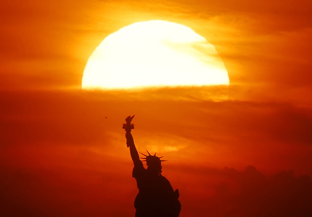 The sun sets behind the Statue of Liberty in New York City on Tuesday, May 7, 2024. (Photo by John Angelillo/UPI/Rex Features/Shutterstock)