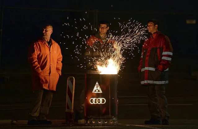 Audi employees warm up around a fire in a barrel during a rally at the factory of the automaker in Ingolstadt, Germany, 29 April 2016. Workers in the metal and electrical industry have begun nationwide strikes at night on 29 April. In several work places employees will temporarily stop working during the day, according to German metalworkers' union IG Metall. Strikers demanded for a pay increase of five percent for 3.8 million employees in the sector. (Photo by Andreas Gebert/EPA)