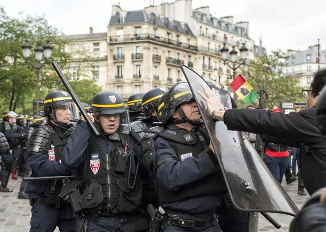 Riot police officers clash with protesters during a demonstration against a labor law bill, Thursday, May 19, 2016 in Paris. France is facing tense weeks of strikes and other union actions against the law, allowing longer workdays and easier layoffs, and which has met fierce resistance in Parliament and in the streets. (Photo by Laurent Cirpriani/AP Photo)