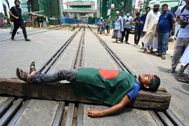 A student blocks a rail track during a protest to demand merit-based system for civil service jobs in Dhaka on July 10, 2024. Thousands of Bangladeshi university students threw roadblocks across key highways on July 7, demanding the end of “discriminatory” quotas for coveted government jobs, including reserving posts for children of liberation heroes. (Photo by Munir Uz Zaman/AFP Photo)