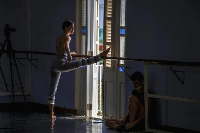 A dancer in Cuba's National Ballet stretches before rehearsing at the ballet's school in Havana, Cuba, Tuesday, April 5, 2022. The National Ballet of Cuba starts rehearsal to return to the stage after more than a year following the COVID-19 pandemic shut down. (Photo by Ramon Espinosa/AP Photo)
