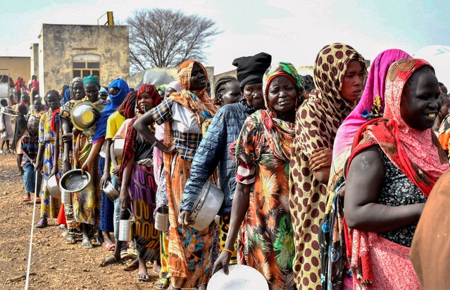 Women who fled the war-torn Sudan following the outbreak of fighting between the Sudanese army and the paramilitary Rapid Support Forces (RSF) queue to receive food rations at the United Nations High Commissioner for Refugees (UNHCR) transit centre in Renk, near the border crossing point in Renk County of Upper Nile State, South Sudan on May 1, 2023. (Photo by Jok Solomun/Reuters)