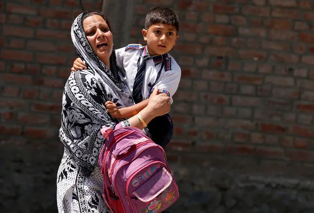 A woman carrying her son tries to leave the spot of a protest in Srinagar, May 23, 2017. (Photo by Danish Ismail/Reuters)