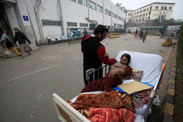 A relative takes care of a patient on a bed after she was taken out of her ward when a group of lawyers stormed the Punjab Institute of Cardiology (PIC) in Lahore, Pakistan on December 11, 2019. (Photo by Mohsin Raza/Reuters)