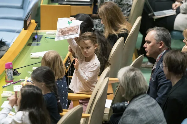 A young member of the Polish delegation shows off a drawing she made during the 30th anniversary of the adoption of the Convention on the Rights of the Child, Wednesday, November 20, 2019, at United Nations headquarters. (Photo by Mary Altaffer/AP Photo)