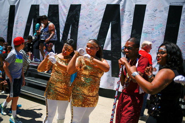 Marching band members from Simmons College of Kentucky pose in front of a banner which reads, “I AM ALI”, while paying tribute to the late boxing champion Muhammad Ali at the Kentucky Center of the Performing Arts in Louisville, Kentucky, U.S. June 8, 2016. (Photo by Adrees Latif/Reuters)
