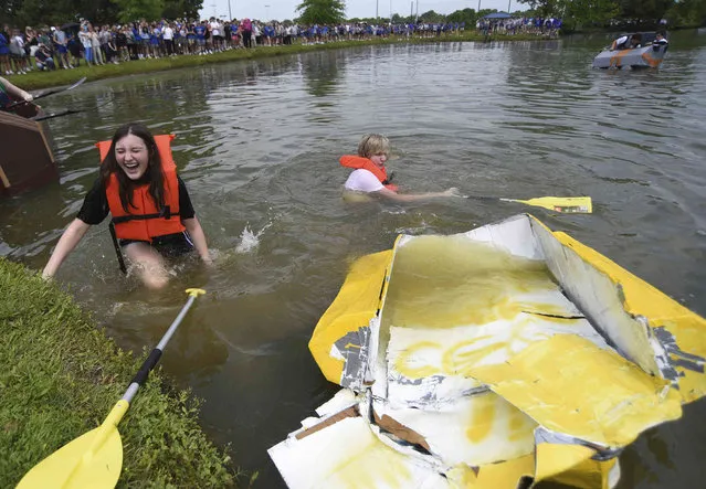 Caroline Greenholtz, 16, and David Browne, 17, are forced to abandon their Beatles-themed Yellow Submarine cardboard boat as it falls apart at Boyd Buchanan School in Chattanooga, Tenn., Wednesday, May 11, 2022. The physics class students were allowed cardboard, duct tape and paint and were tasked with making a boat that could compete in the 25th Annual Physics Boat Race on “Lake Buccaneer” on school property. The two completed the race but the boat began taking on water as they returned to shore. (Photo by Matt Hamilton/Chattanooga Times Free Press via AP Photo)