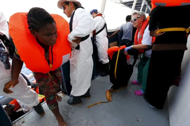 Migrants are helped to board the Migrant Offshore Aid Station (MOAS) ship MV Phoenix, some 20 miles (32 kilometres) off the coast of Libya, August 3, 2015. (Photo by Darrin Zammit Lupi/Reuters)