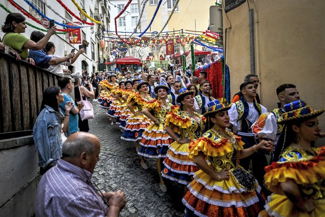 Revellers from the typical Lisbon neighbourhood, Alfama, parade in the streets before attending the Santo Antonio de Lisboa's Parade on Avenida da Liberdade, in Lisbon, on June 12, 2023. Lisbon celebrates Saint Anthony's day, the city's protector saint, with a parade that gathers participants from several typical neighbourhoods of the city. (Photo by Patrícia de Melo Moreira/AFP Photo)