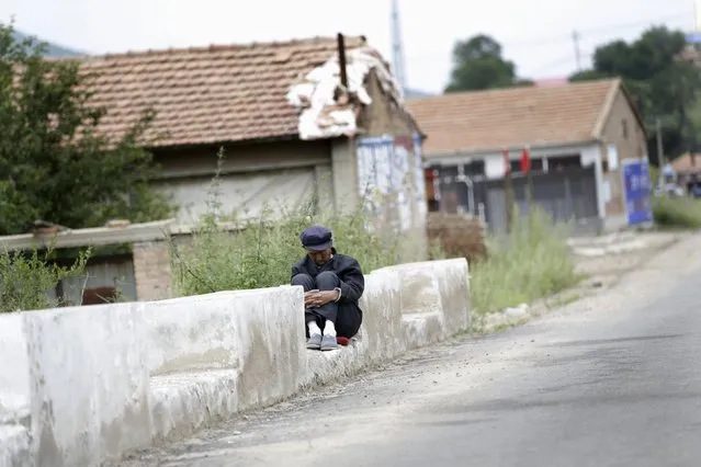 A local villager takes a nap beside a road at a village near Dolomiti Mountain Resort in Chongli county of Zhangjiakou, jointly bidding to host the 2022 Winter Olympic Games with capital Beijing, July 31, 2015. (Photo by Jason Lee/Reuters)