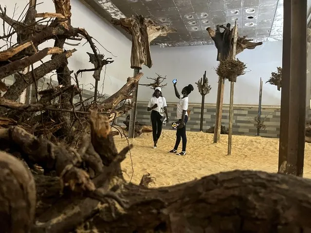 Visitors take pictures of art installations during the 14th edition of Senegal's Biennale of African Contemporary Art, in Dakar, Senegal, May 19, 2022.. (Photo by Elodie Toto/Reuters)