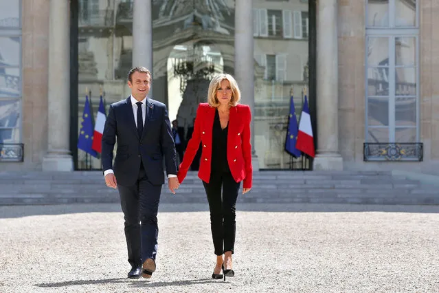 French President Emmanuel Macron and his wife Brigitte Macron walk toward the Elysee Palace courtyard, to welcome autistics people, prior to the launching of a program to enhance the diagnosis and treatment of autism, in Paris, France, July 6, 2017. (Photo by Thibault Camus/Reuters)