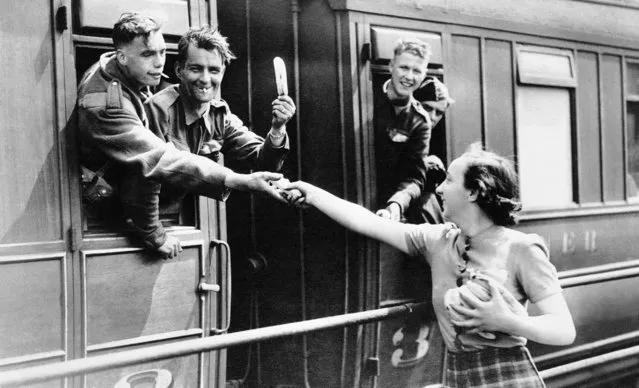 British troops arriving in England on June 6, 1940 after fleeing Flanders received all kinds of fruit and food from women who passed it out to them as they halted in railroad stations. A soldier holds aloft a banana he received from the woman. (Photo by AP Photo)