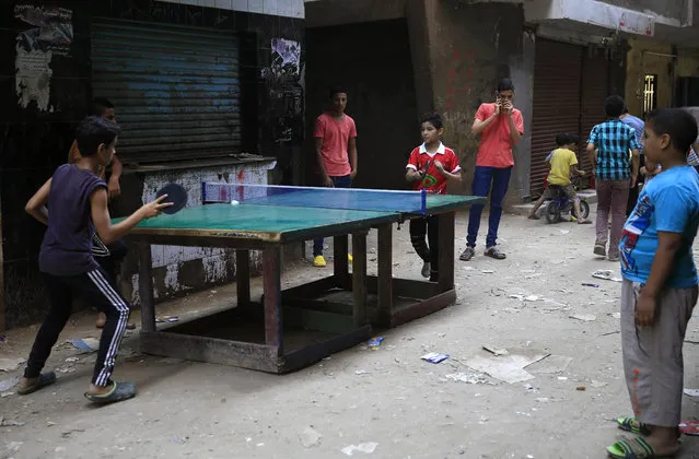 Egyptian boys play table tennis in an alleyway at the Boulaq El Dakrour district of Giza, near Cairo, Egypt, Sunday, July 5, 2015. (AP Photo/Hassan Ammar)