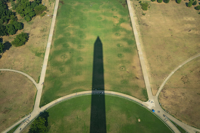 Individuals gather in the shadow of the Washington Monument in Washington, DC, on July 16, 2024. (Photo by Allison Robbert/The Washington Post)