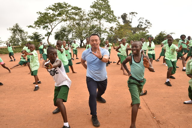 Chinese martial arts teacher Liu Wei (C) practices an excercise with students of the Fourah Bay College Secondary School in Freetown during a training session at the Confucius Institute University of Sierra Leone on October 15, 2024. The Chinese language and martial arts teachings are becoming popular amongst school children in several school institutions in Freetown and at the Fourah Bay College Secondary School since it was established in the country in 2012 to promote people to people traditional and cultural exchanges and for deepening friendship and cooperation with the People's Republic of China. (Photo by Saidu Bah/AFP Photo)